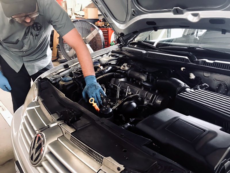 Photo of man working under the hood of a car